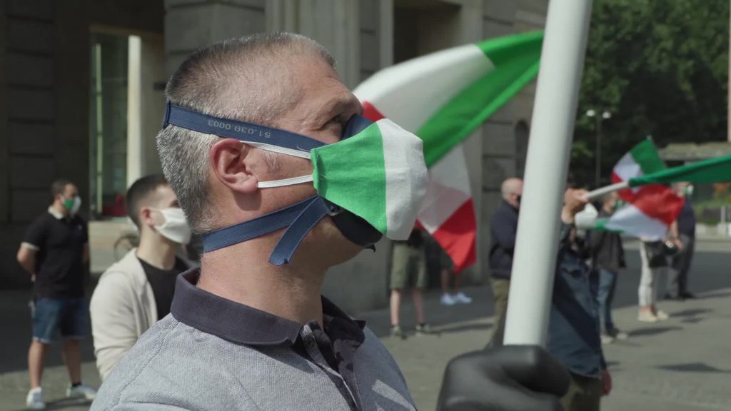 Mascherine tricolore in Piazza XXV aprile a Milano per protestare contro il governo