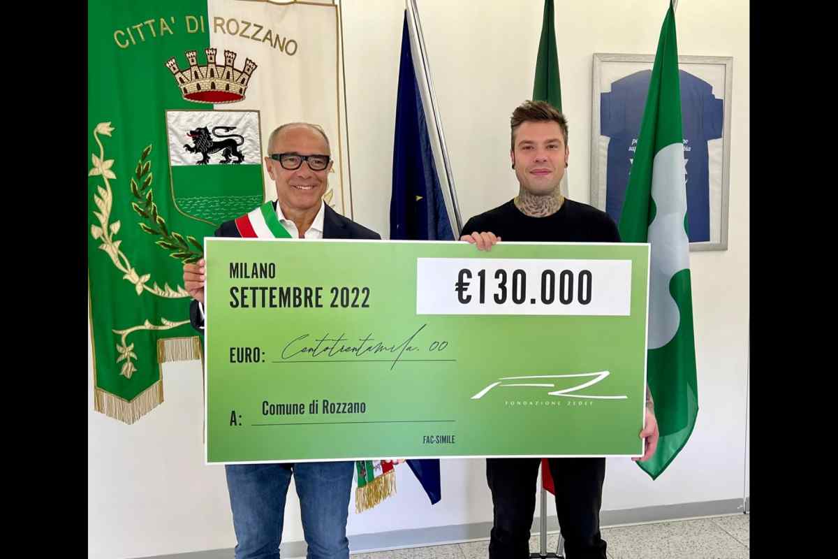 Il sindaco di Rozzano regge un assegno gigante assieme a Fedez